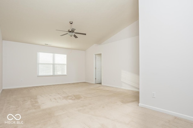 empty room with light carpet, ceiling fan, baseboards, and vaulted ceiling