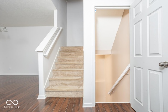 stairway with wood finished floors and baseboards