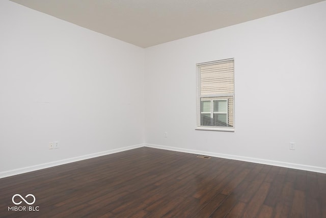 spare room with dark wood-style floors and baseboards