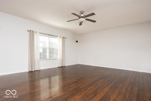 spare room with dark wood-style flooring, ceiling fan, a textured ceiling, and baseboards