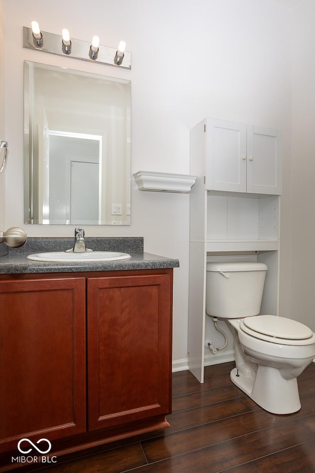 bathroom featuring vanity, wood finished floors, and toilet