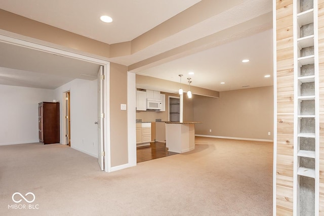 unfurnished living room with baseboards, recessed lighting, and light colored carpet