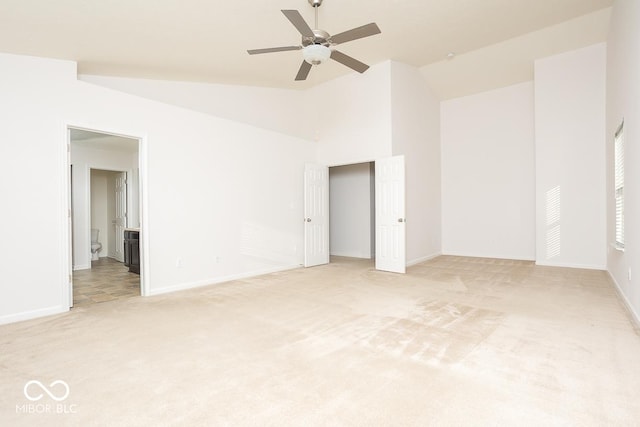 unfurnished room featuring ceiling fan, baseboards, vaulted ceiling, and light colored carpet