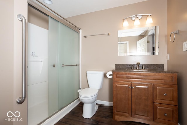 full bath featuring toilet, a stall shower, wood finished floors, and vanity