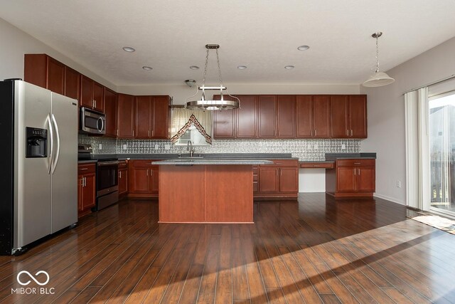 kitchen featuring dark wood-style floors, appliances with stainless steel finishes, a sink, and tasteful backsplash