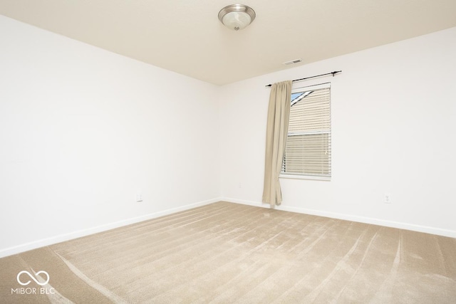 spare room with light carpet, baseboards, and visible vents