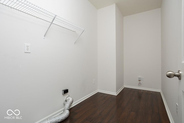 clothes washing area featuring laundry area, baseboards, and dark wood finished floors