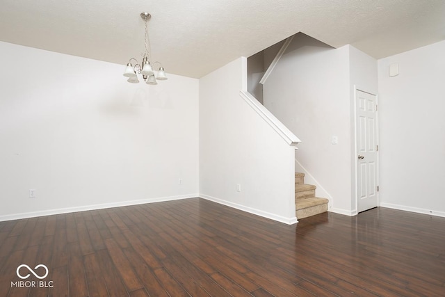 spare room with a textured ceiling, stairway, hardwood / wood-style flooring, and baseboards