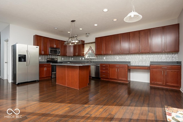 kitchen with dark wood-style floors, appliances with stainless steel finishes, pendant lighting, and a sink