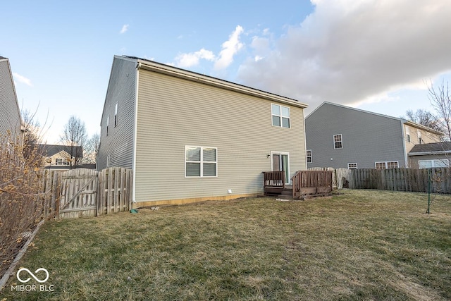 back of house with a wooden deck, a yard, a fenced backyard, and a gate