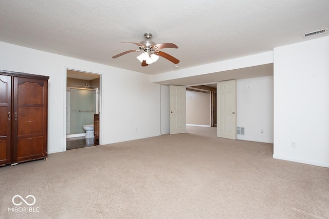 interior space with baseboards, ceiling fan, visible vents, and a textured ceiling