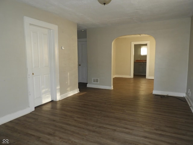 spare room with dark wood-type flooring