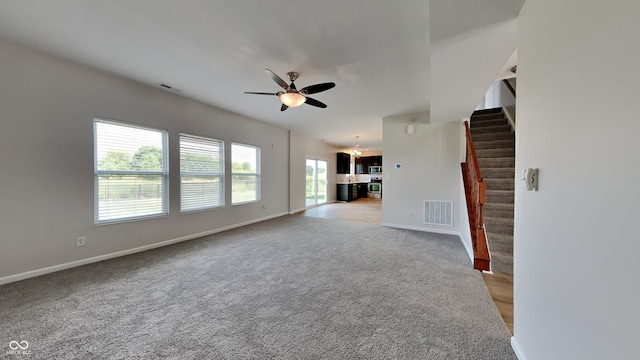 unfurnished living room with ceiling fan and light carpet