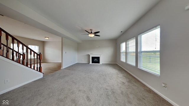 unfurnished living room featuring ceiling fan and carpet floors