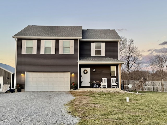 view of front of property with a yard, a porch, and a garage