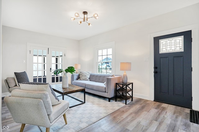 living room featuring a chandelier and light wood-type flooring