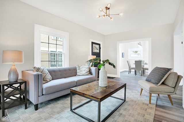 living room featuring wood-type flooring and an inviting chandelier