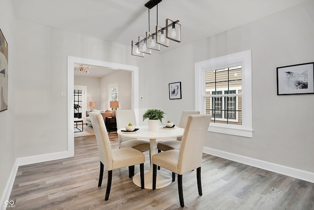 dining area featuring wood-type flooring and an inviting chandelier