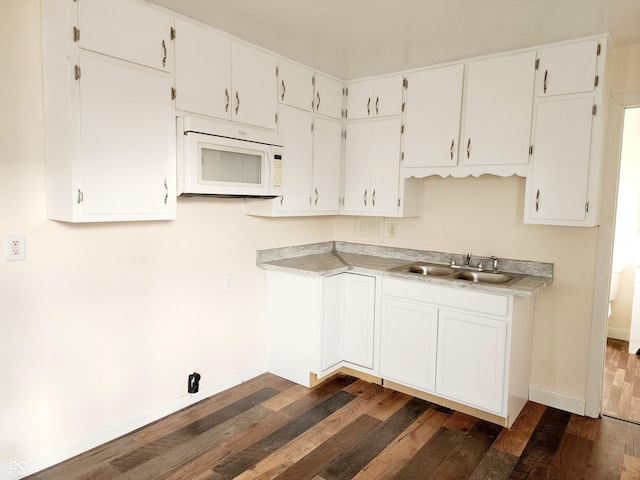 kitchen with white cabinets, sink, and dark wood-type flooring