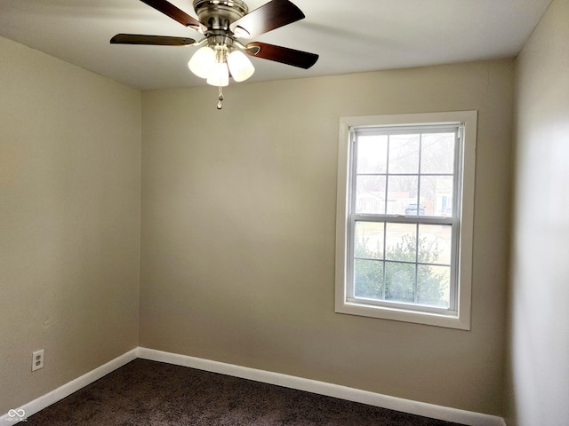 empty room with ceiling fan and dark carpet