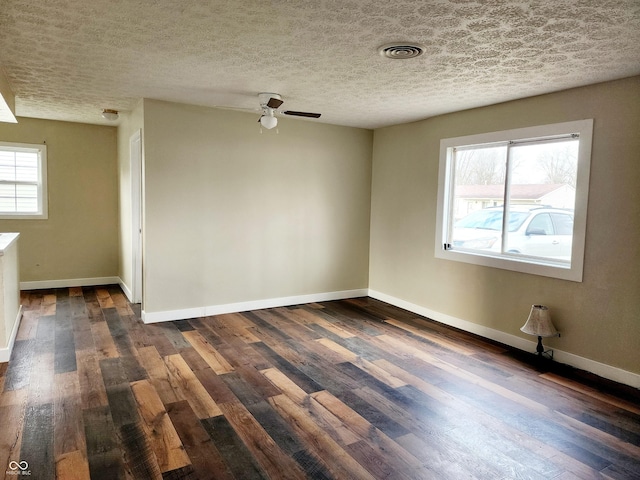 empty room featuring ceiling fan, dark hardwood / wood-style flooring, and a textured ceiling