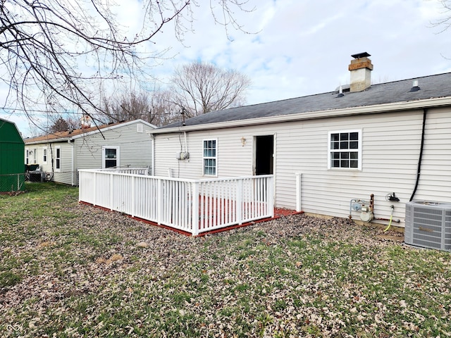 rear view of house with central air condition unit, a yard, and a deck