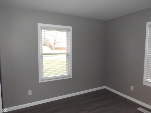 unfurnished room with dark hardwood / wood-style flooring