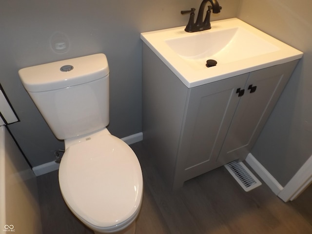 bathroom featuring vanity, wood-type flooring, and toilet