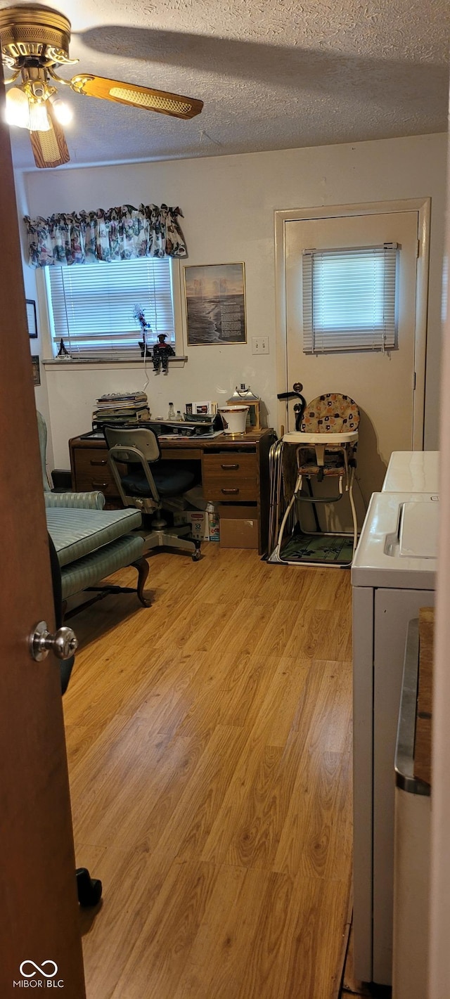 office area featuring hardwood / wood-style floors, ceiling fan, separate washer and dryer, and a textured ceiling