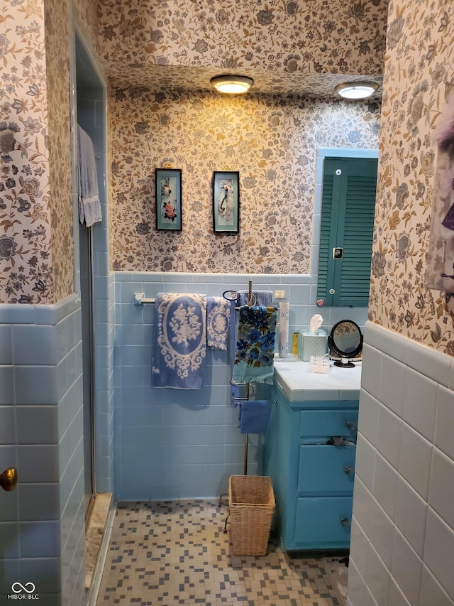 bathroom featuring vanity and tile walls