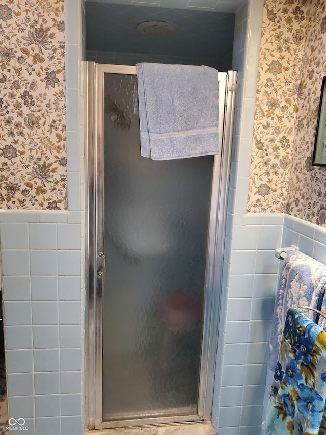 bathroom with walk in shower and tile walls