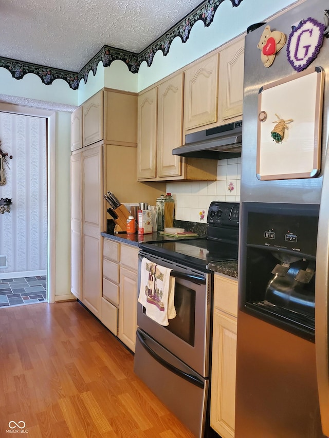 kitchen featuring appliances with stainless steel finishes, a textured ceiling, light hardwood / wood-style flooring, and backsplash