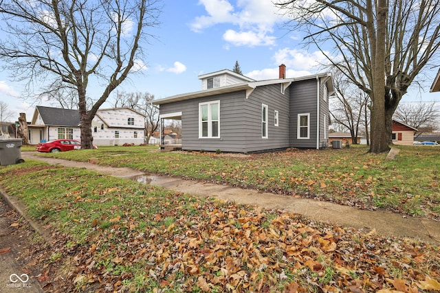 view of property exterior featuring a yard and central AC