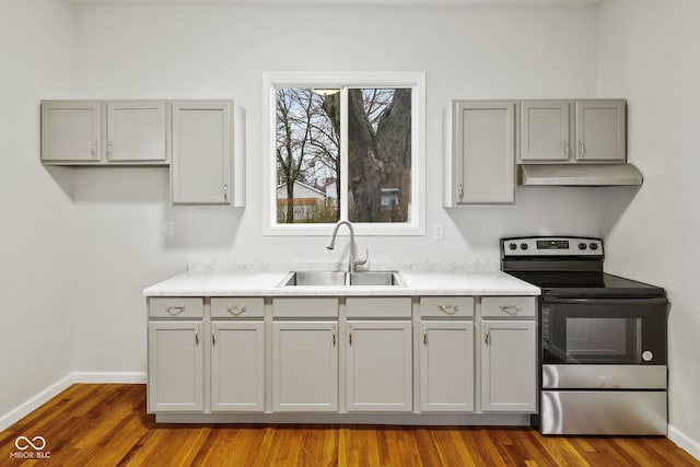 kitchen featuring gray cabinets, electric range, sink, and dark wood-type flooring