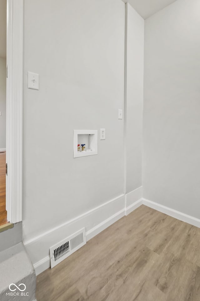 washroom with hardwood / wood-style floors and hookup for a washing machine