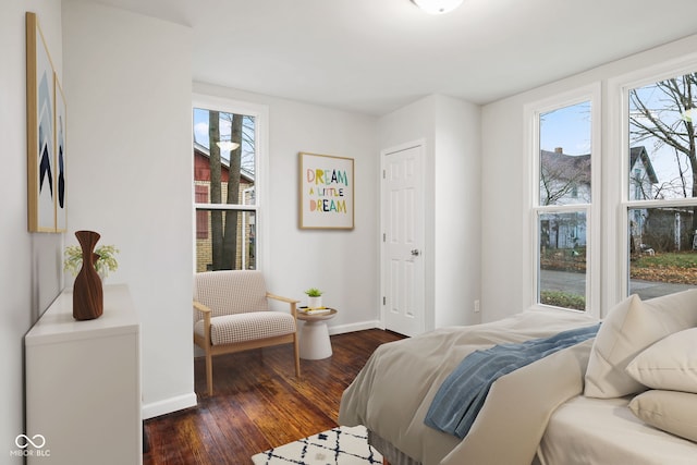 bedroom with dark hardwood / wood-style floors and multiple windows