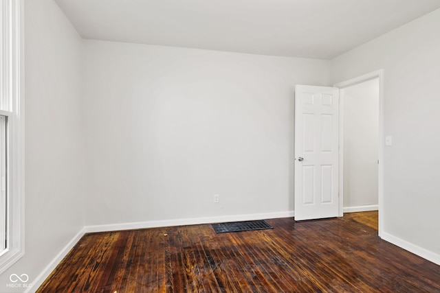 unfurnished room with dark wood-type flooring