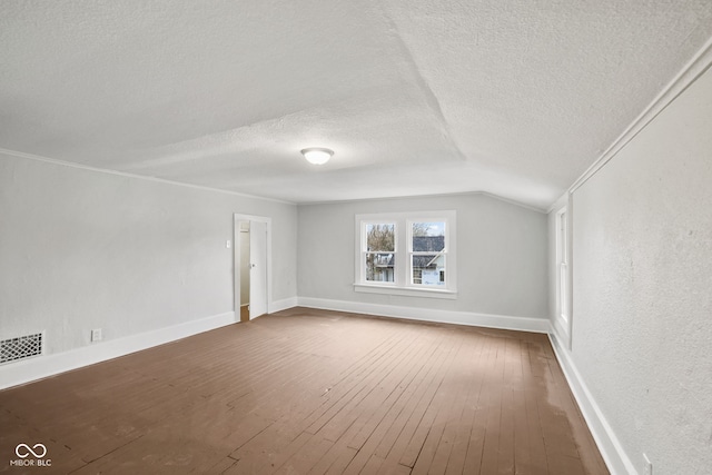 bonus room featuring vaulted ceiling, wood-type flooring, and a textured ceiling