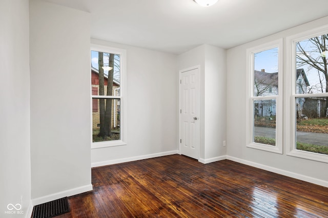 unfurnished room with plenty of natural light and dark hardwood / wood-style floors