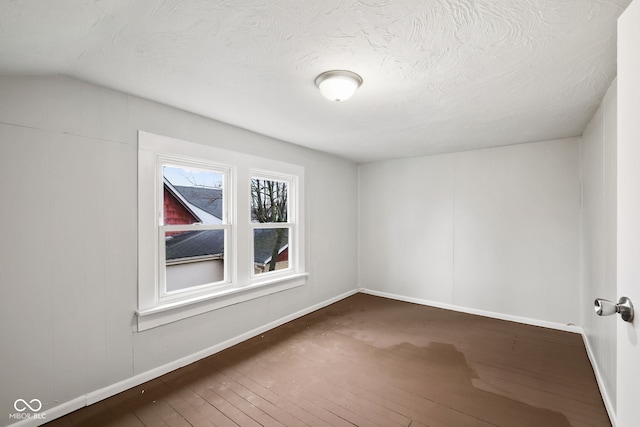 additional living space featuring wood-type flooring and a textured ceiling