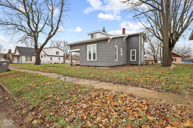 view of home's exterior with cooling unit and a lawn