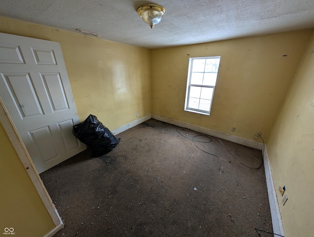 unfurnished room featuring a textured ceiling