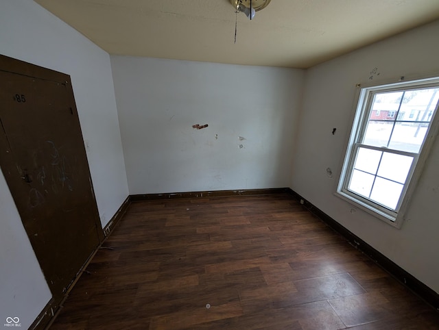 unfurnished room featuring plenty of natural light and dark wood-type flooring