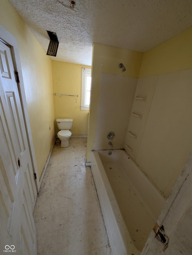 bathroom featuring a textured ceiling and toilet