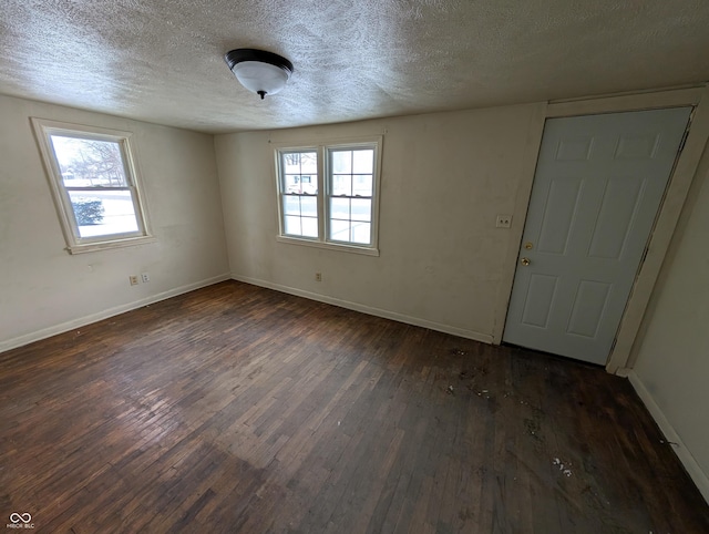 unfurnished room featuring a textured ceiling and dark wood-type flooring