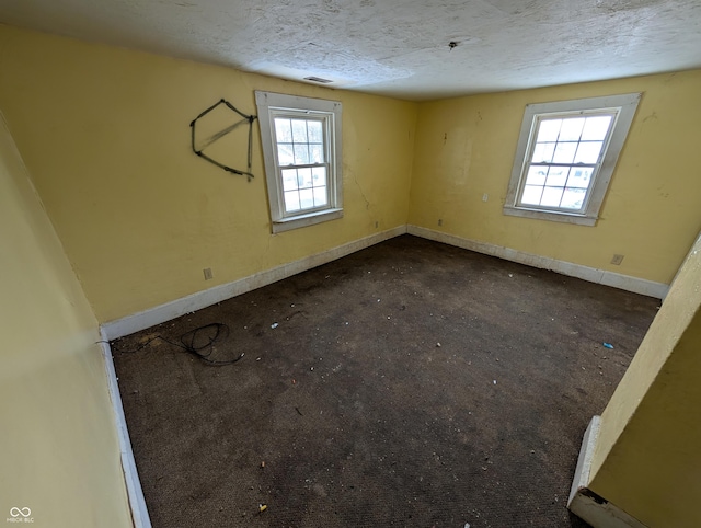 empty room featuring a textured ceiling and a healthy amount of sunlight