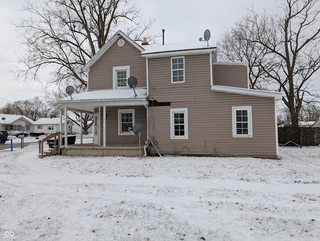 snow covered property featuring covered porch