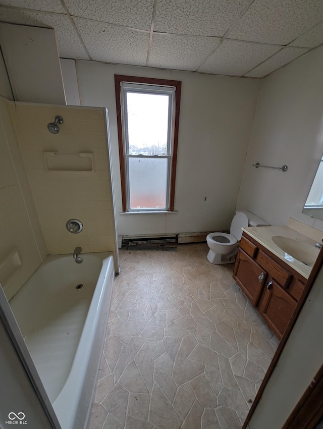 bathroom featuring vanity, baseboard heating, toilet, and a drop ceiling