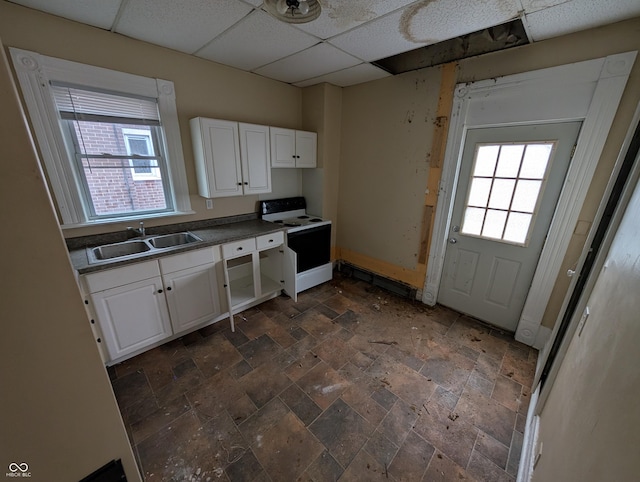 kitchen featuring a paneled ceiling, white range with electric cooktop, white cabinets, sink, and a wealth of natural light