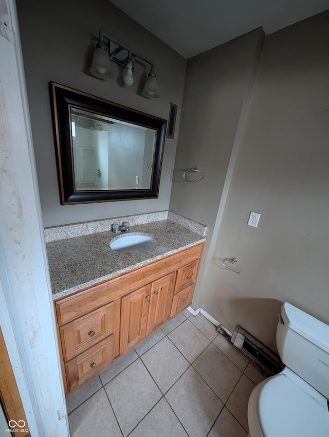 bathroom featuring tile patterned flooring, vanity, and toilet